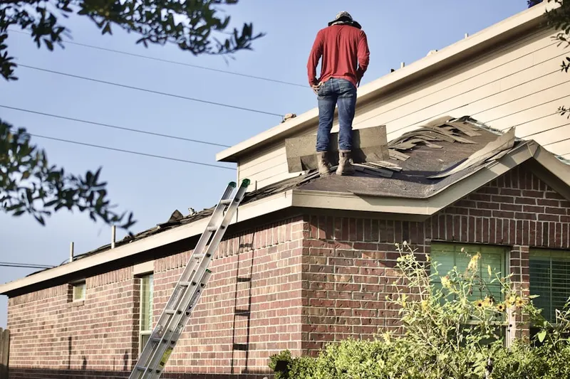 Professional roofer working on a residential roof in Linden Chapel Hills